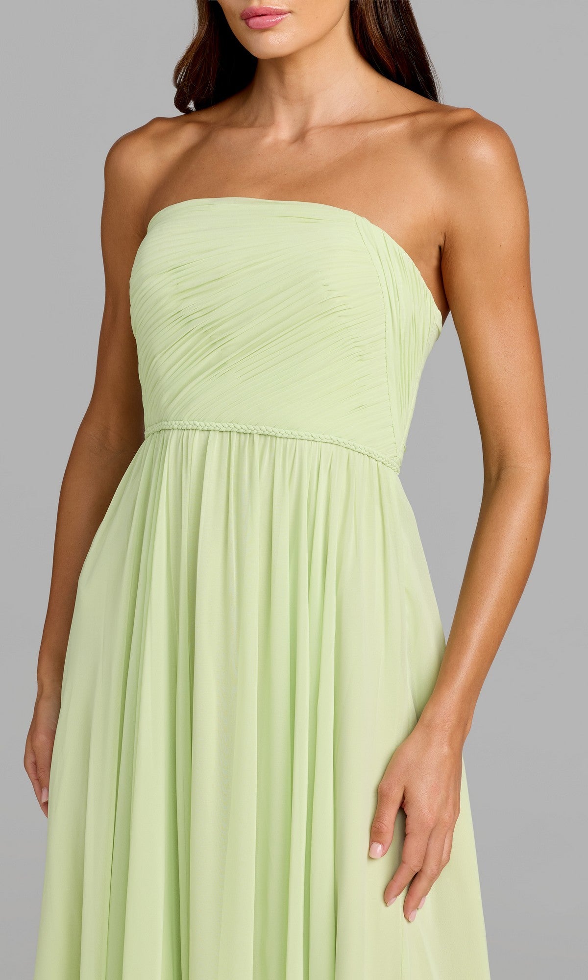A woman stands against a plain gray background wearing the Mac Duggal 68847 long formal dress—a strapless light green chiffon gown featuring a ruched bodice and a flowing A-line skirt.